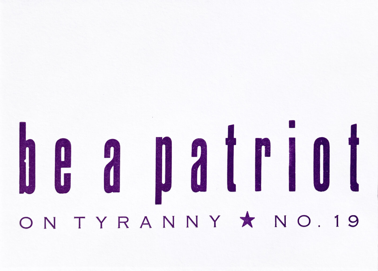 Letterpress print in purple ink on white paper with text that reads "Be a Patriot On Tyranny No. 19"